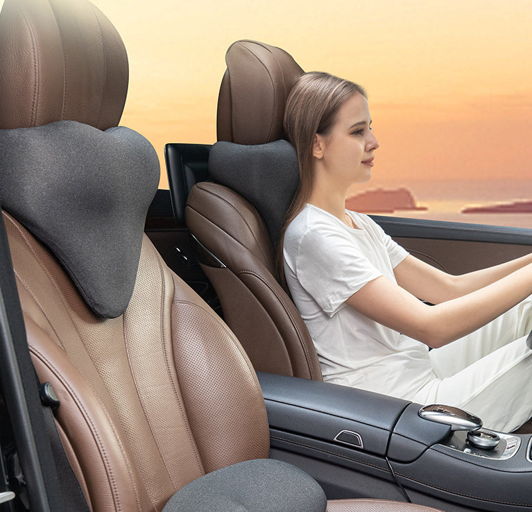 Woman driving car with ergonomic neck pillow on brown seat, sunset view, sps street style