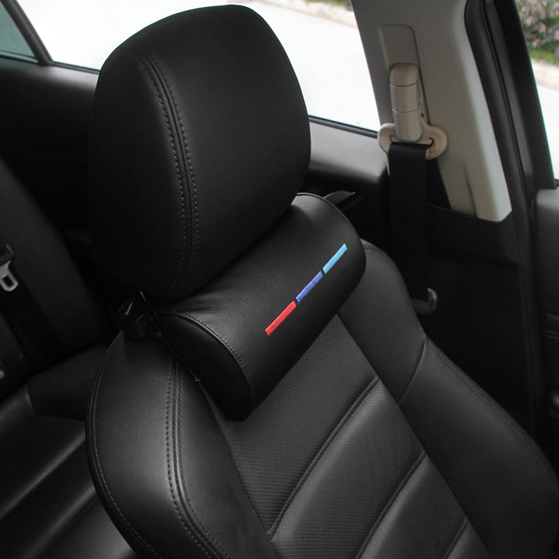 Black leather car seat with ergonomic headrest pillow featuring red, blue, and light blue stripes