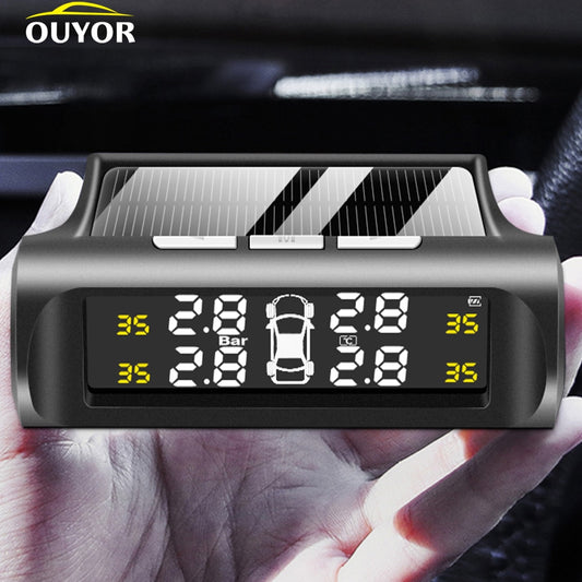Hand holding a digital tire pressure monitor for cars, solar-powered, with bright display