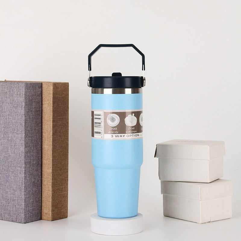 Blue travel tumbler with black handle on a table, quality gift from sps street style