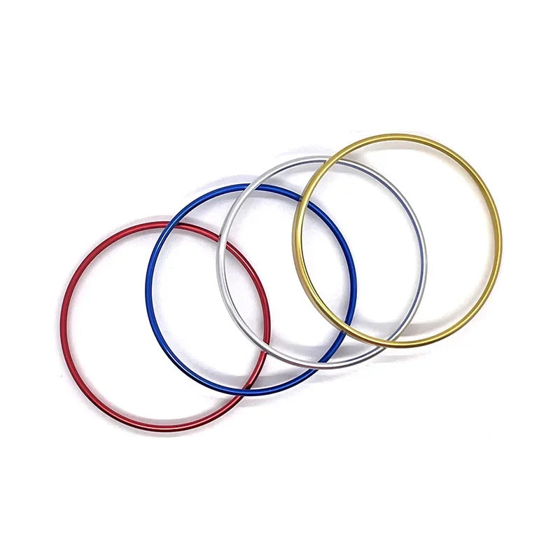 Set of four colorful metal bangles in red, blue, silver, and gold on white background